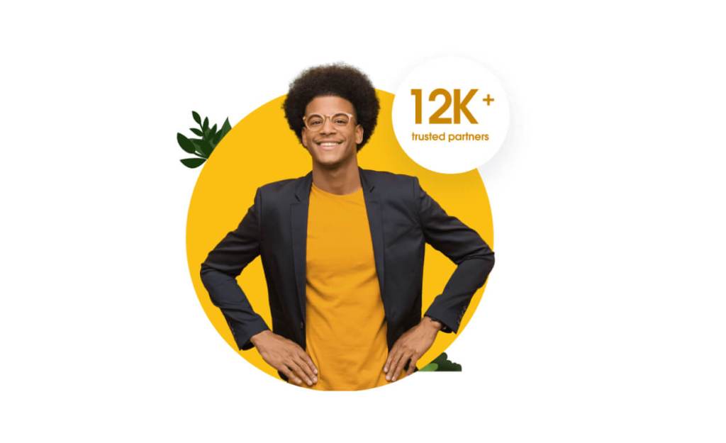 Ein lächelnder Salesforce-Partner mit einem Badge mit der Aufschrift „12.000 vertrauenswürdige Partner“