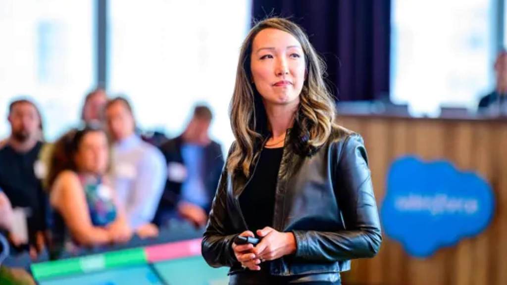 Woman in a black jacket leads a Salesforce presentation