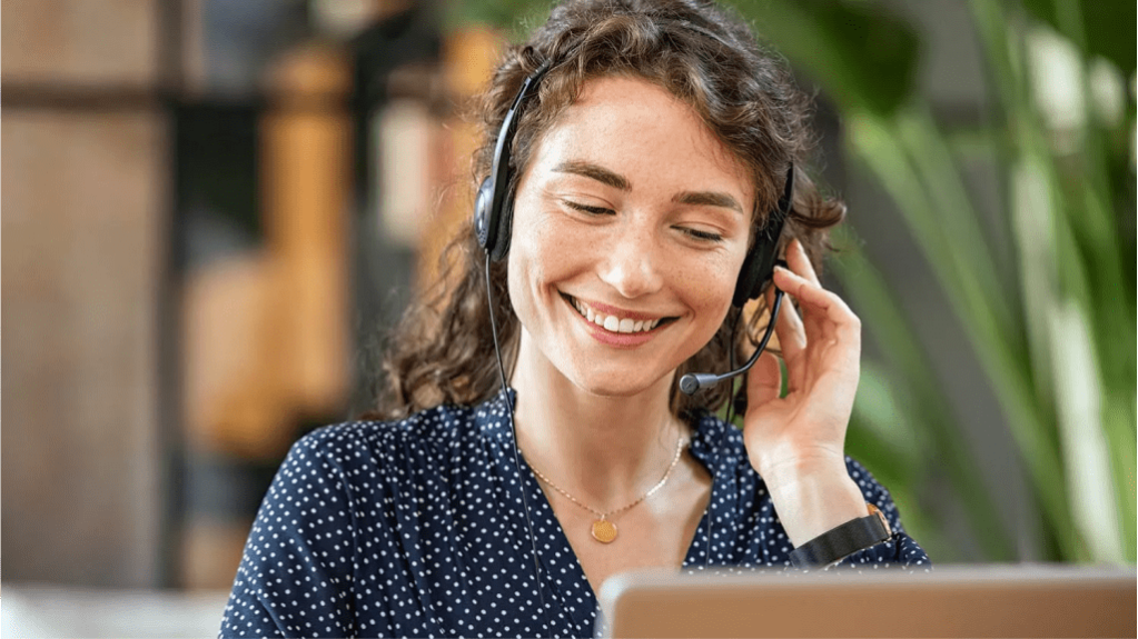 Woman with a headset on pressing one earphone down.