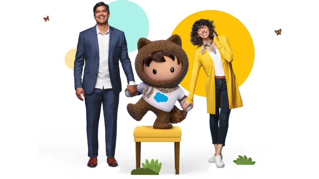 Astro wearing a salesforce t-shirt and holding hands with a smiling woman and man