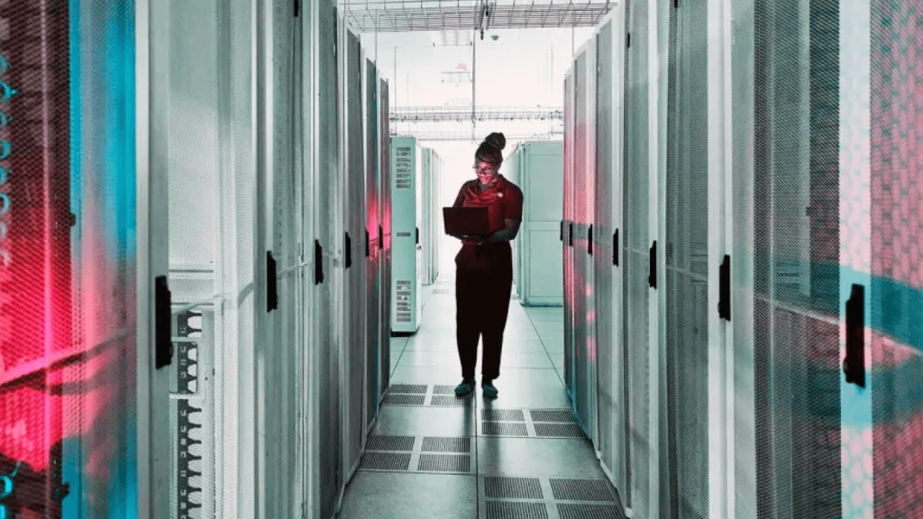 A woman with a laptop in a server farm