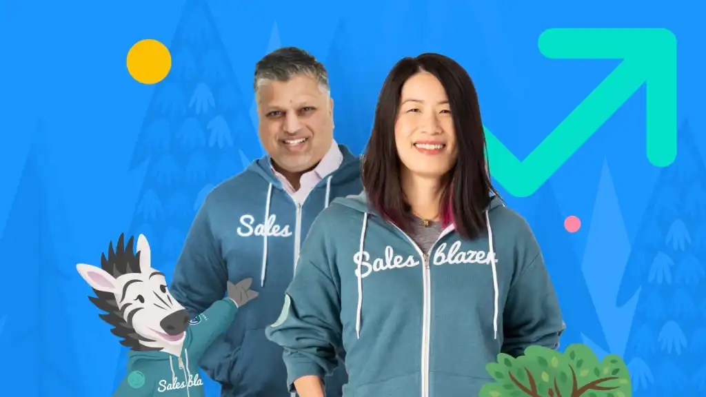 Kaksi Salesblazer-jäsentä huppareissaan poseeraa Salesforce-hahmon Zigin vieressä.